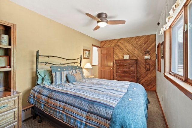 112 N Pine St, Breckenridge, CO 80424 - carpeted bedroom featuring wood walls, a baseboard radiator, multiple windows, a ceiling fan, and baseboards