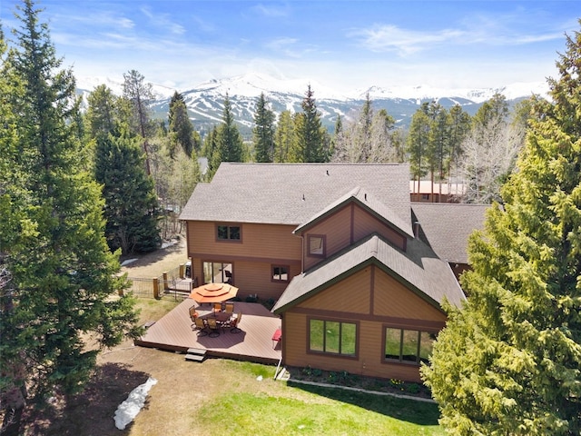 112 N Pine St, Breckenridge, CO 80424 - back of house featuring a deck with mountain view, roof with shingles, and a lawn