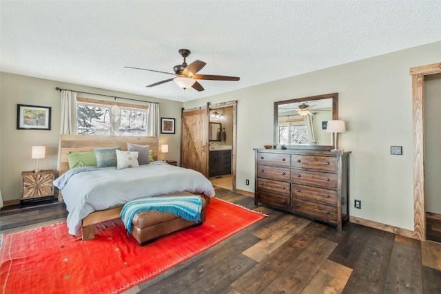 58195 Jupiter Pl, Clark, CO 80428 - bedroom featuring ensuite bath, a barn door, baseboards, and wood finished floors