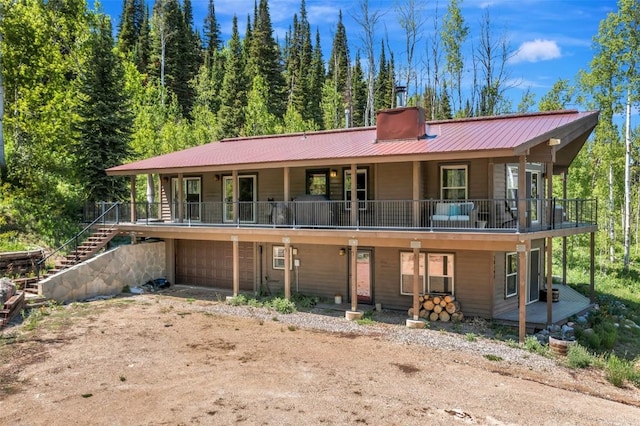 58195 Jupiter Pl, Clark, CO 80428 - view of front of property featuring dirt driveway, a garage, a metal roof, and a wooded view