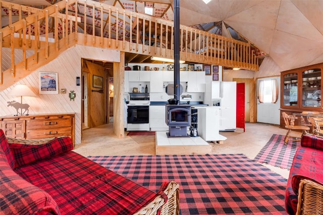 902 Hawk Way, Como, CO 80456 - living area featuring a wood stove, wood walls, light colored carpet, and high vaulted ceiling