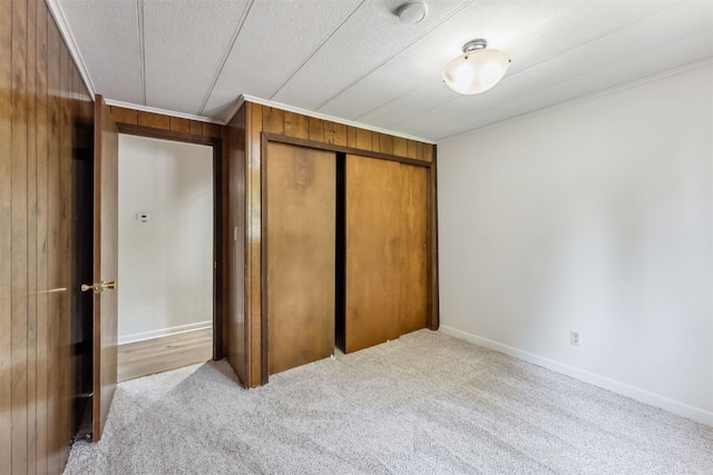 361 Lagoon Ln, Silverthorne, CO 80498 - unfurnished bedroom with carpet flooring, a closet, wood walls, ornamental molding, and baseboards