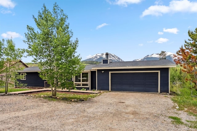 361 Lagoon Ln, Silverthorne, CO 80498 - view of front of home with dirt driveway, a garage, and a mountain view
