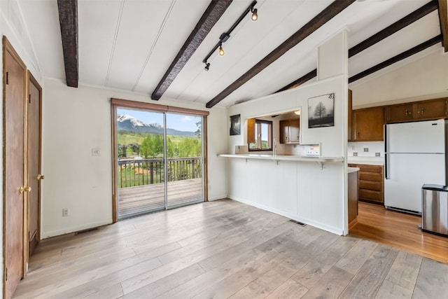 361 Lagoon Ln, Silverthorne, CO 80498 - kitchen featuring freestanding refrigerator, light countertops, a kitchen breakfast bar, a peninsula, and light wood-style flooring