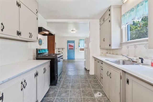 190 N Walnut St, Hayden, CO 81639 - kitchen with range with gas stovetop, ventilation hood, freestanding refrigerator, light countertops, and white cabinets