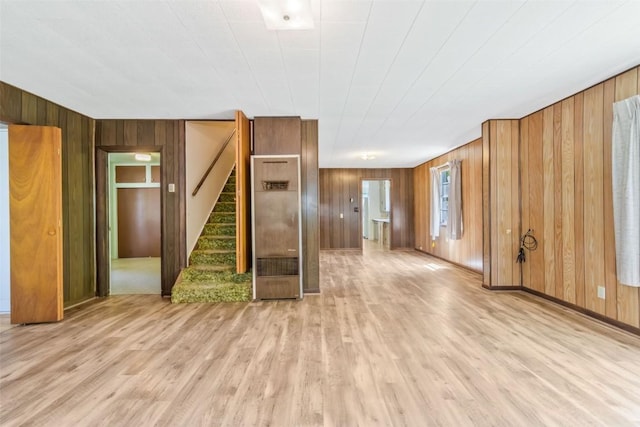 190 N Walnut St, Hayden, CO 81639 - unfurnished living room with wooden walls, light wood finished floors, stairs, and a heating unit