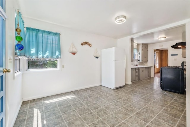 190 N Walnut St, Hayden, CO 81639 - kitchen with freestanding refrigerator, light countertops, premium range hood, and light tile patterned floors