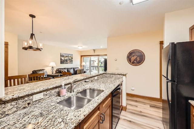 22787 US Highway 6 Unit 313, Keystone, CO 80435 - kitchen with black appliances, a sink, light wood-style flooring, baseboards, and light stone countertops