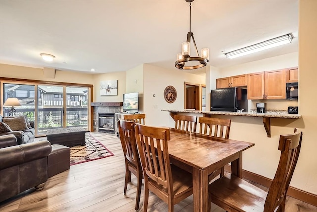 22787 US Highway 6 Unit 313, Keystone, CO 80435 - dining room featuring light wood-style floors, a fireplace, and a chandelier