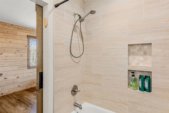 bathroom featuring washtub / shower combination and wood finished floors