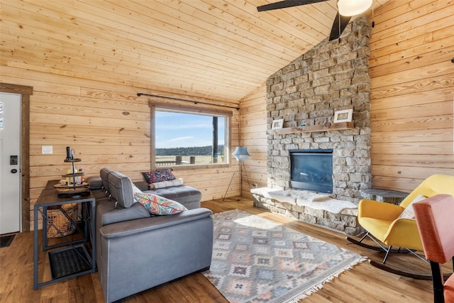 living area with vaulted ceiling, wood walls, wood finished floors, wood ceiling, and a fireplace