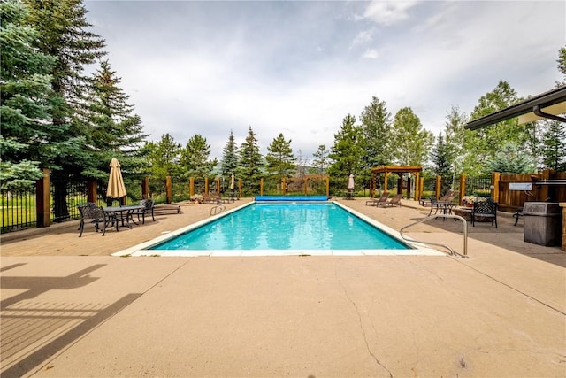 community pool with fence and a patio