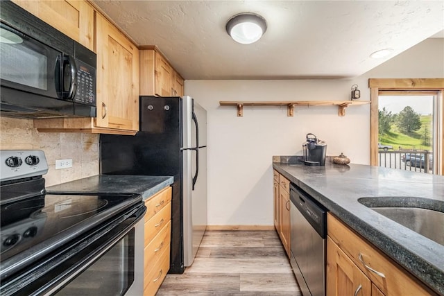 kitchen with stainless steel appliances, dark stone counters, light wood-style floors, decorative backsplash, and open shelves