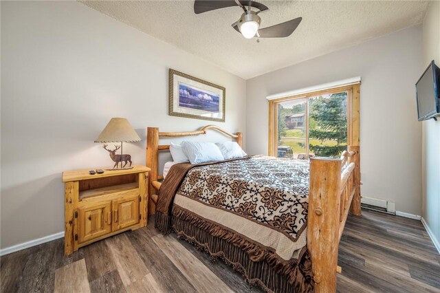 1945 Cornice Rd Unit 2221, Steamboat Springs, CO 80487 - bedroom featuring a ceiling fan, baseboards, a baseboard radiator, a textured ceiling, and dark wood-style flooring