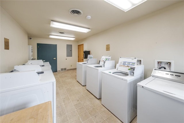 community laundry room with visible vents, electric panel, and separate washer and dryer