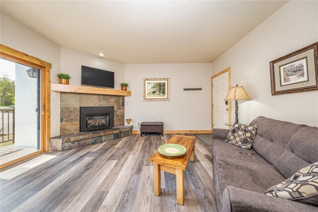 1945 Cornice Rd Unit 2221, Steamboat Springs, CO 80487 - living room featuring wood finished floors, a tiled fireplace, and baseboards