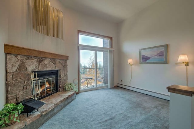 unfurnished living room with a baseboard radiator, carpet floors, a fireplace, and a high ceiling