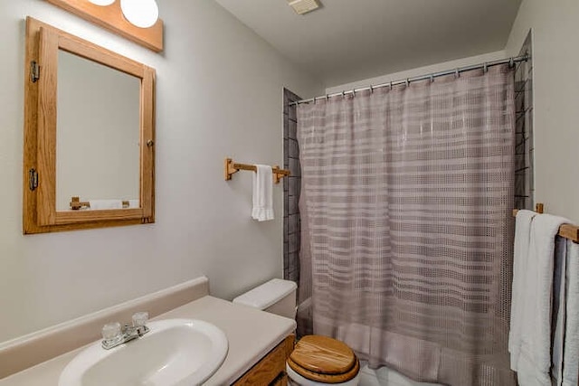 bathroom with shower / tub combo, vanity, and toilet