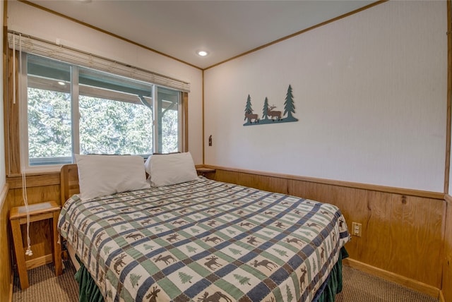 carpeted bedroom featuring wainscoting, wood walls, ornamental molding, and multiple windows