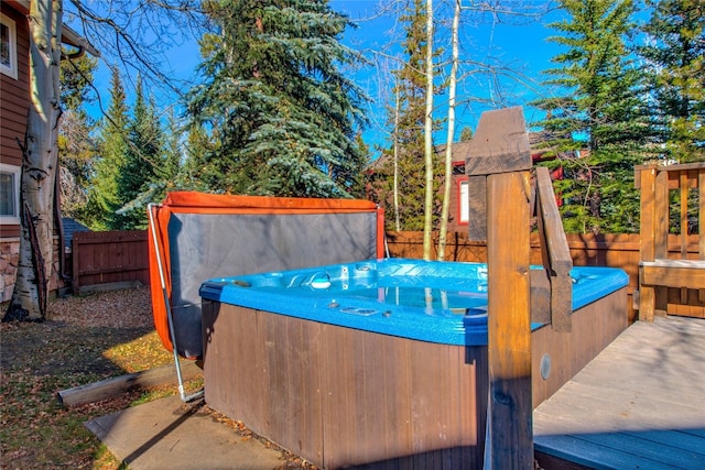 exterior space with a fenced backyard, a wooden deck, and a hot tub