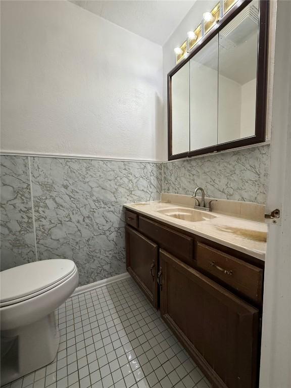 635 School St, Craig, CO 81625 - half bath with vanity, toilet, and tile patterned flooring