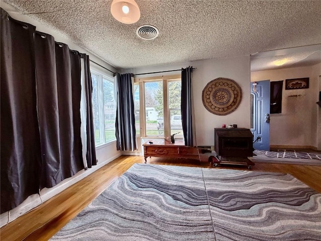 635 School St, Craig, CO 81625 - bedroom featuring wood finished floors, a textured ceiling, baseboards, and a wood stove