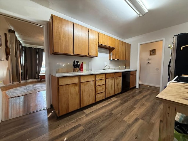 635 School St, Craig, CO 81625 - kitchen featuring dishwasher, refrigerator, dark wood-style flooring, light countertops, and brown cabinetry