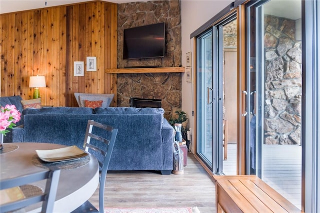 72 Corinthian Cir Unit 303, Dillon, CO 80435 - living area featuring a stone fireplace, wood finished floors, and wood walls