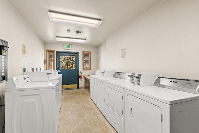 community laundry room with washing machine and dryer, baseboards, and visible vents