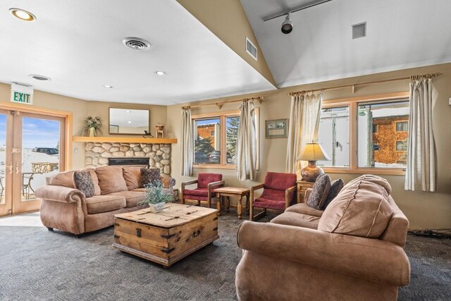 living room featuring rail lighting, carpet flooring, visible vents, and a fireplace