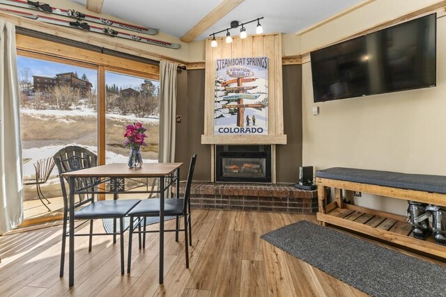 dining room featuring a large fireplace and wood finished floors