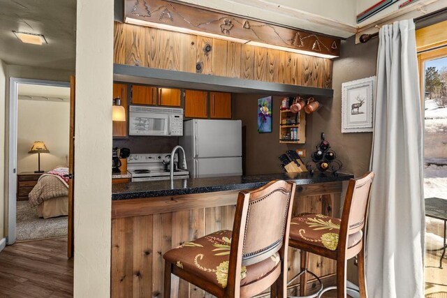 bar with wood finished floors and white appliances
