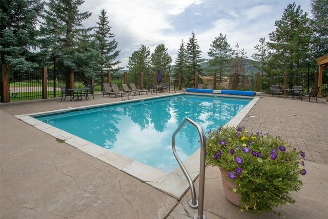 pool featuring fence and a patio