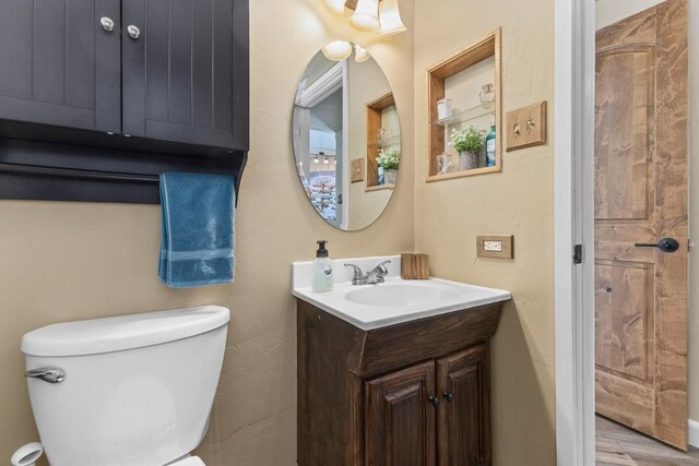 half bathroom with vanity and toilet