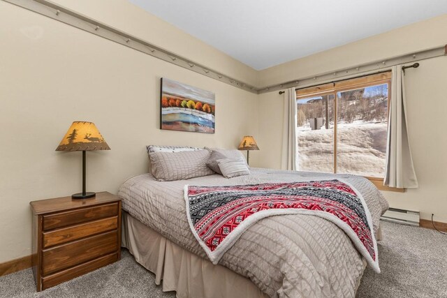 carpeted bedroom with baseboard heating and baseboards