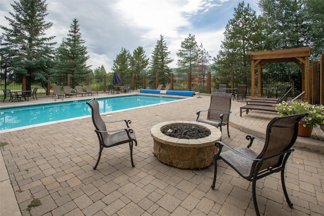 community pool featuring fence, a patio, and an outdoor fire pit