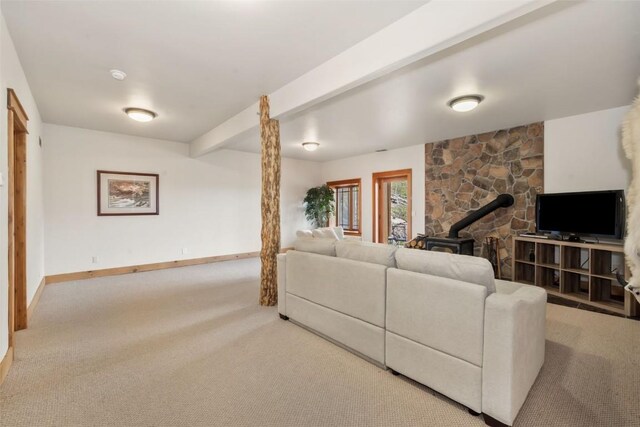 51193 Smith Creek Park Rd, Steamboat Springs, CO 80487 - carpeted living room with a wood stove, baseboards, and beam ceiling