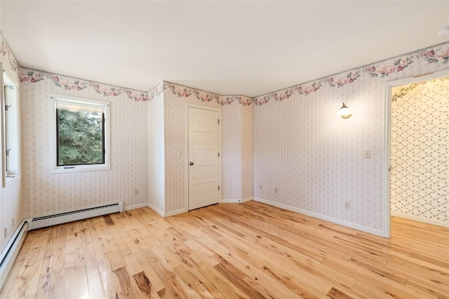 203 Spruce St, Steamboat Springs, CO 80487 - empty room with hardwood / wood-style flooring, a baseboard heating unit, baseboard heating, wallpapered walls, and baseboards