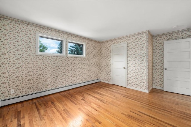 203 Spruce St, Steamboat Springs, CO 80487 - unfurnished bedroom with a baseboard heating unit, light wood-style flooring, wallpapered walls, and baseboards