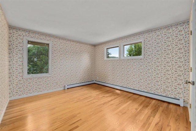 203 Spruce St, Steamboat Springs, CO 80487 - spare room featuring light wood-type flooring, baseboard heating, wallpapered walls, and baseboards