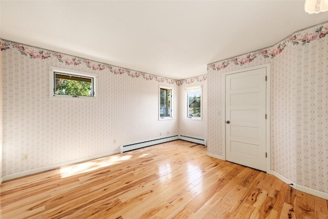 203 Spruce St, Steamboat Springs, CO 80487 - empty room featuring light wood finished floors, baseboard heating, baseboards, and wallpapered walls