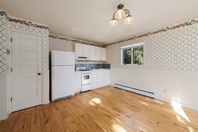 203 Spruce St, Steamboat Springs, CO 80487 - kitchen with white appliances, a baseboard radiator, wallpapered walls, light wood finished floors, and under cabinet range hood
