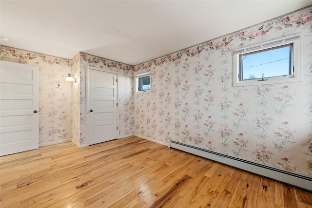 203 Spruce St, Steamboat Springs, CO 80487 - empty room featuring baseboard heating, light wood finished floors, and wallpapered walls