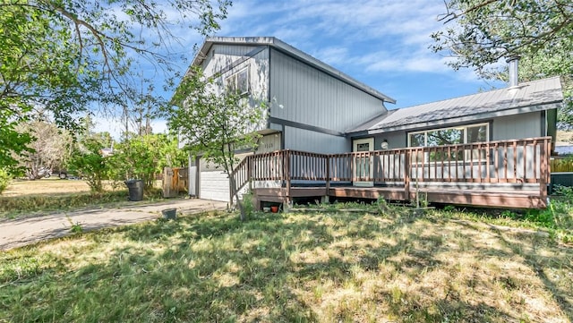 1226 Barclay St, Craig, CO 81625 - back of house with concrete driveway, a metal roof, a wooden deck, and an attached garage