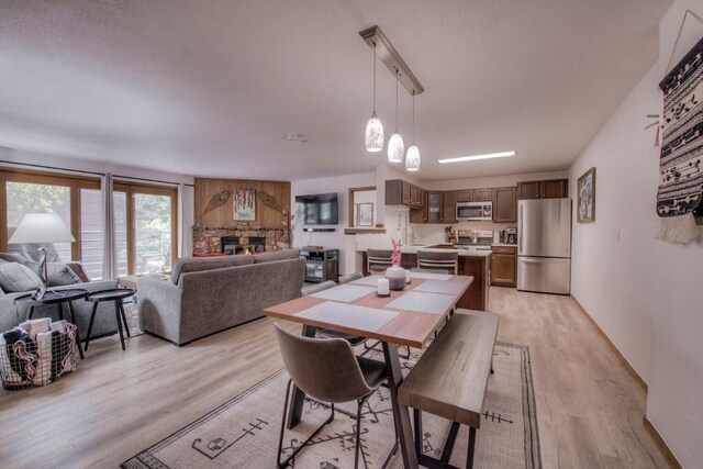 23034 US Highway 6 Unit 305, Keystone, CO 80435 - dining area featuring light wood-type flooring and a stone fireplace