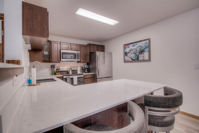 23034 US Highway 6 Unit 305, Keystone, CO 80435 - kitchen with stainless steel appliances, a peninsula, a sink, and a breakfast bar area
