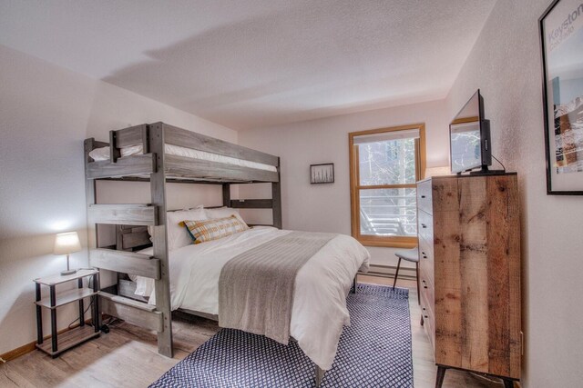 23034 US Highway 6 Unit 305, Keystone, CO 80435 - bedroom with baseboards, baseboard heating, and wood finished floors
