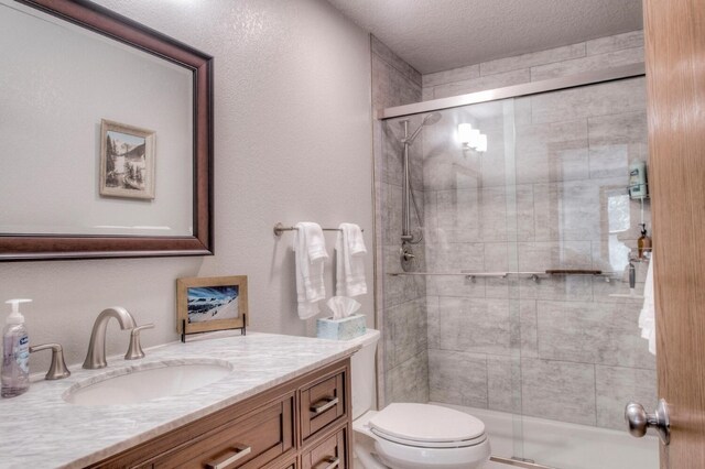 23034 US Highway 6 Unit 305, Keystone, CO 80435 - full bathroom with a shower stall, toilet, vanity, and a textured ceiling