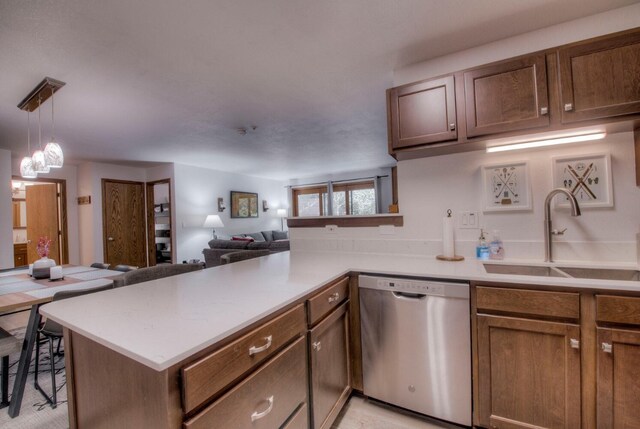 23034 US Highway 6 Unit 305, Keystone, CO 80435 - kitchen featuring stainless steel dishwasher, a sink, open floor plan, light countertops, and a peninsula