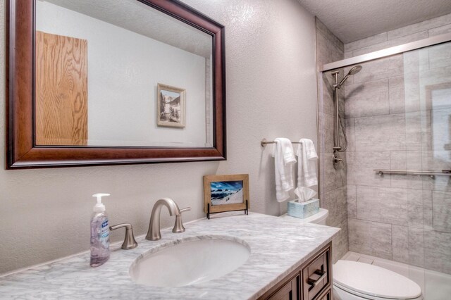 23034 US Highway 6 Unit 305, Keystone, CO 80435 - full bath featuring a textured wall, vanity, a shower stall, and toilet